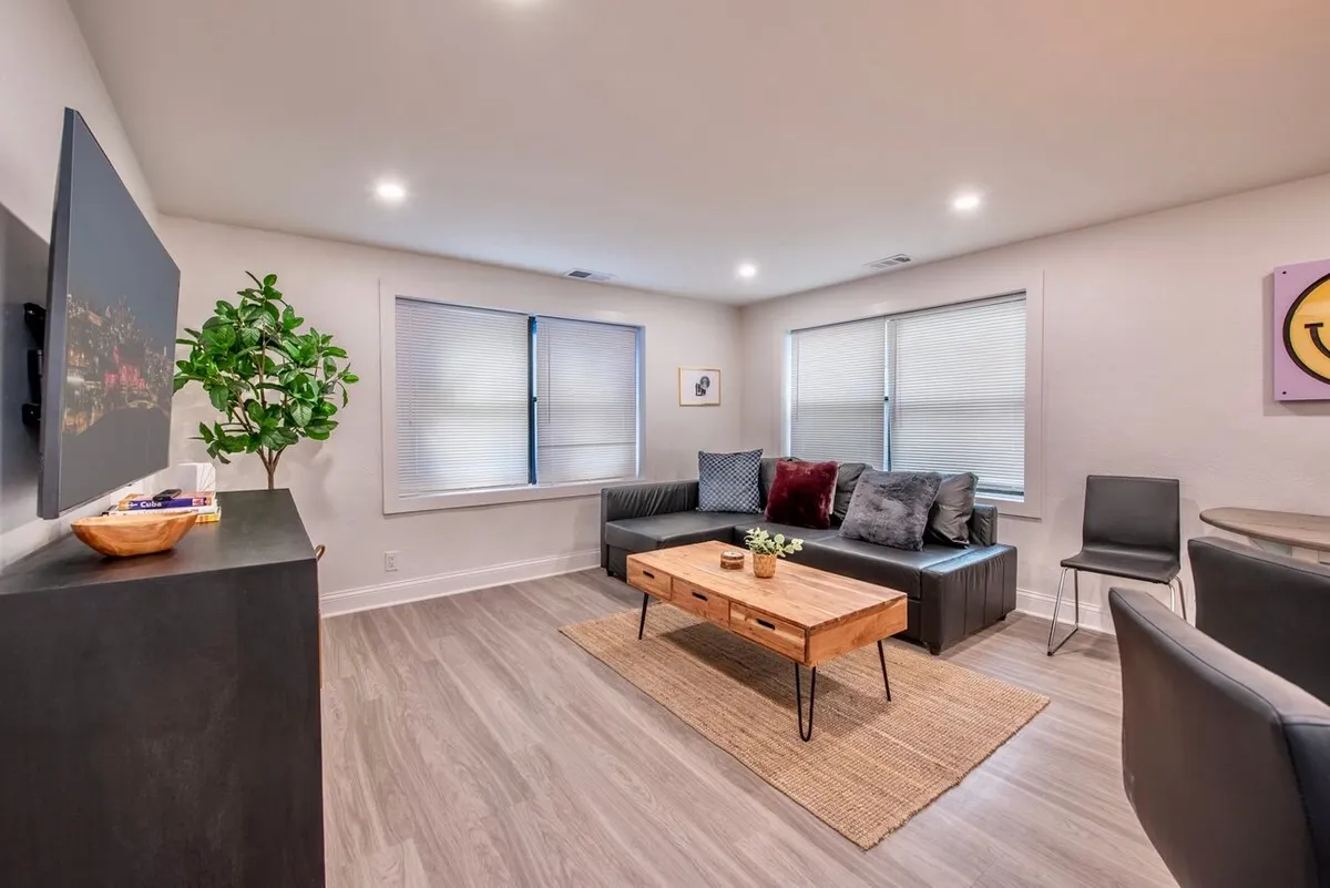 A casual and cozy living room scene centered around a plush sofa, coffee table, TV, and a touch of greenery from a plant. The atmosphere exudes comfort, making it perfect for unwinding, watching TV, or enjoying casual gatherings with friends or family.