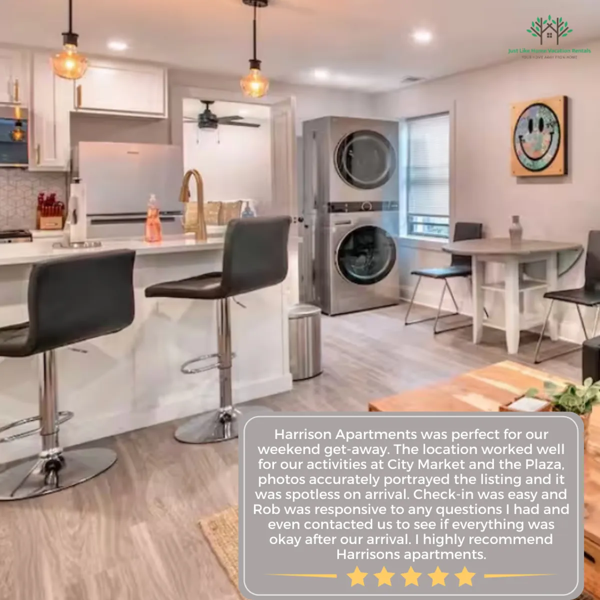 A contemporary kitchen scene with a central island, sleek bar stools, washer and dryer, and colorful artwork on the wall. The space is open, practical, and perfectly suited for socializing or everyday routines, with ample natural light enhancing the modern aesthetic.